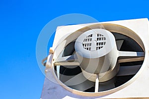 Closeup view from inside the galvanized steel air duct on the exhaust fan in the background light, the front and back background