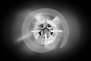 Closeup view from inside the galvanized steel air duct on the exhaust fan in the background light, the front and back background