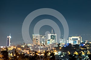 A closeup view of Kigali city skyline lit up at night, under a d photo