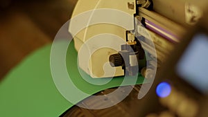 Closeup view of light-green rubber belt or band running under mechanical device