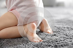 Closeup view of little baby on grey carpet