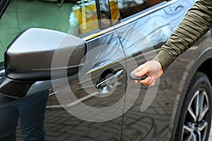 Closeup view of man opening car door with key