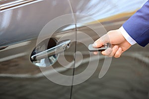 Closeup view of man opening car door with key