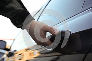 Closeup view of man opening car door outdoors