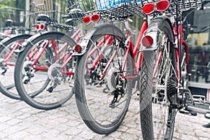 Closeup view many red city bikes parked in row at european city street rental parking sharing station or sale. Healthy