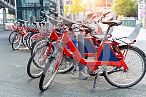 Closeup view many red city bikes parked in row at german Hamburg city street rental parking sharing station or sale