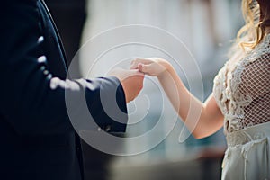 Closeup view of married couple holding hands.