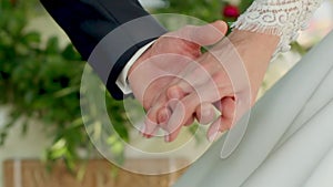 Closeup view of married couple holding hands