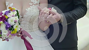 Closeup view of married couple holding hands. Bride and groom outdoor wedding video