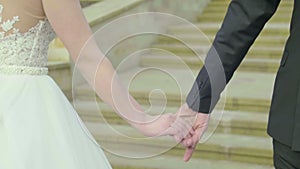 Closeup view of married couple holding hands. Bride and groom outdoor wedding video