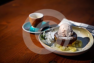Closeup view of a molten chocolate cake with an ice-cream and a coffee