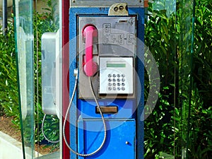 closeup view of old blue retro style dial type coin operated street telephone with push button dial pad