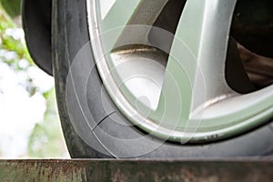Closeup view of an old dirty car wheel with winter tires and silver brake disc. Selective focus