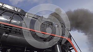 Closeup view old steam locomotive train boiler with black grey smoke.