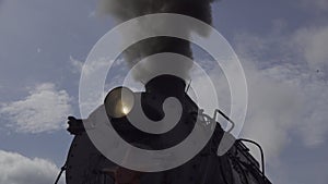 Closeup view old steam locomotive train boiler with black grey smoke. Sound