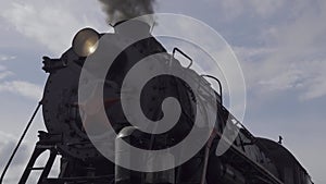 Closeup view old steam locomotive train boiler headlight with black smoke. Sound