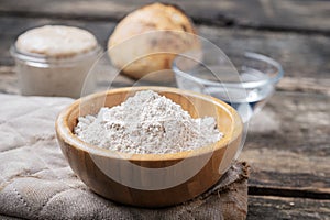 Closeup view of organic whole spelt flour in wooden cup