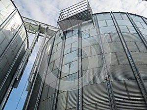 Closeup view of paddy rice storage steel silo in a milling plant. Agriculture produces storage technologies.