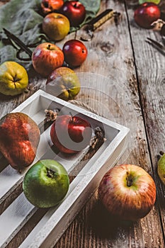 closeup view of pears, apples, wooden box, scissors, hand scales and kitchen towel