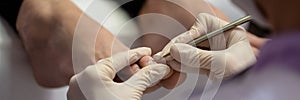 Closeup view of pedicurist removing dead skin from toenails