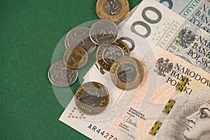 Closeup view of polish money banknotes and coins - zloty and groszy on green as financial background. Cash money. Financial growth