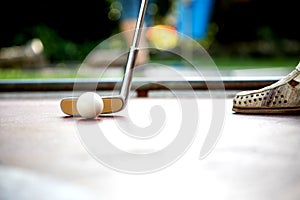 Closeup view from a professional minigolf player hitting a white