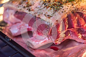 Closeup view raw beef cross rib chunk on oven tray with foil inside oven photo