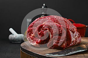 Closeup view of raw beef neck on wooden stump