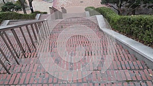 Closeup view of red brick stairs with dark concrete lines on footsteps