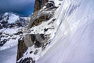 Dramatic View of Snowy Sheer Mountain Cliff in Alaska. photo