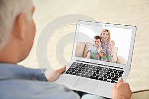 Closeup view of senior man talking with family members via video chat