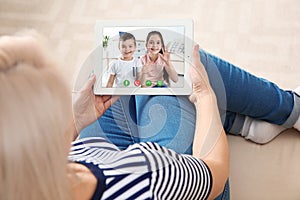 Closeup view of senior woman talking with grandchildren via video chat