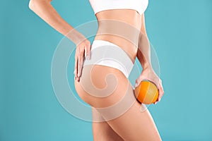 Closeup view of slim woman in underwear with orange. Cellulite problem concept