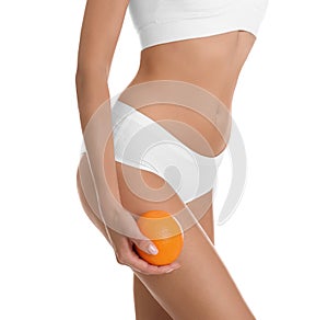 Closeup view of slim woman in underwear with orange on white background.