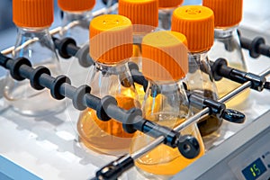 Closeup view of test tubes with samples shaker equipment in pharma or chemical manufacturing plant photo