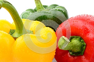 Closeup view of three coloured pepper isolated white