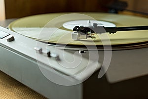 Closeup view of a tonearm and turntable playing color vinyl record