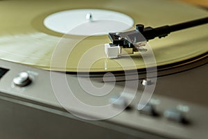 Closeup view of a tonearm and turntable playing color vinyl record