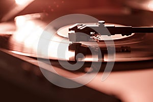 Closeup view of a tonearm and turntable playing vinyl record