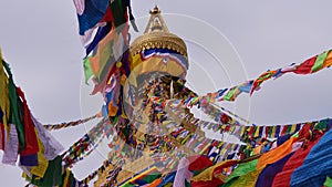 Closeup view of the top Boudhanath stupa in the center of Kathmandu, Nepal with prayer flags flying in the wind.