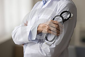 Closeup view unknown woman doctor in white coat holding stethoscope