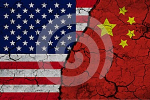 A closeup view of the US flag and the flag of China against the backdrop of cracked earth. The concept of the crisis of the war of