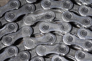 Closeup View of Used Greasy Oiled Bicycle Chain As A Part of Metal Bicycle Equipment On Stony Background With Contrast Details