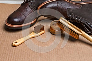 Closeup View of Various Shoes Cleaning Accessories for Dark Brown Grain Brogue Derby Boots Made of Calf Leather Over Tile