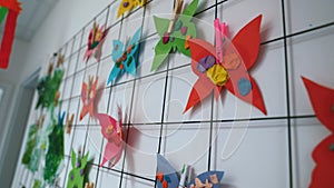 closeup view of a was full of paper-made colorful butterflies, kids' handcrafts at nursery, creative activities