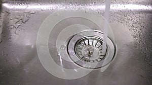 Closeup view of wasteful water flow in kitchen sink