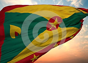 Closeup view of the waving flag of the Grenada on a background of sunset
