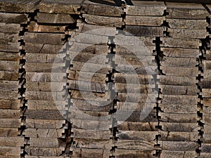 View of weathered pile of stacked wooden planks with wood texture.