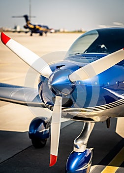Closeup view of white propeller of the blue sport plane nose