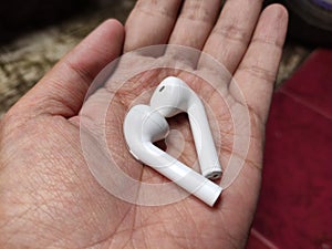 Closeup view white Wireless Tws Earphones on hand. selective focus.